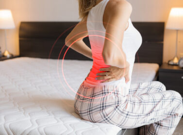 Woman suffering from back pain because of uncomfortable mattress